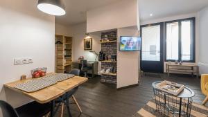 a kitchen and living room with a table and a television at L'Atelier fil à fil in Le Mans