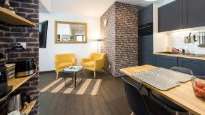 a kitchen with a table and two yellow chairs at L'Atelier fil à fil in Le Mans