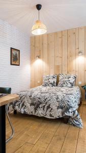 a bedroom with a bed and a table and a lamp at L'Atelier Corval in Le Mans