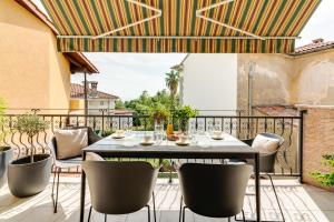 un patio con tavolo e sedie sul balcone. di Luxury Apartment Regina a Opatija