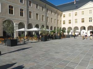a courtyard in a building with tables and umbrellas at L'Atelier Corval in Le Mans +8 photos