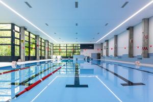 une grande piscine d'eau bleue dans l'établissement Sport Resort Fiesch, Garni Aletsch, à Fiesch