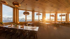 a large room with tables and chairs and windows at Haus Edelweiss in Bad Ragaz