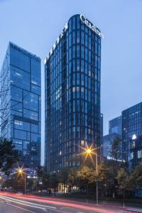 un grand bâtiment en verre avec un panneau sur celui-ci dans l'établissement Citadines South Chengdu, à Chengdu