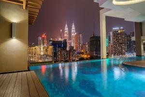 a pool with a view of a city at night at Tamu Hotel & Suites Kuala Lumpur in Kuala Lumpur