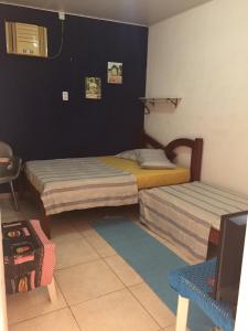 sypialnia z dwoma łóżkami i telewizorem w obiekcie Pousada da Didi w mieście Belém