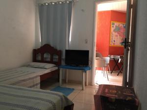 1 dormitorio con 2 camas y mesa con TV en Pousada da Didi en Belém