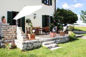 eine Terrasse mit einer Steinmauer und einem Sonnenschirm in der Unterkunft Charmante Chiemgauwohnung in Wasserburg am Inn