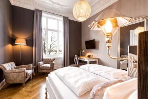 um quarto com uma grande cama branca e uma cadeira em Hotel Alsterblick em Hamburgo