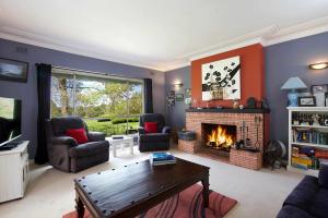 a living room with a fireplace and chairs and a table at The Nineteenth in Blackheath