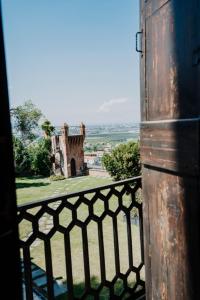 uma vista para um castelo a partir de uma varanda em Castello Rosso em Costigliole Saluzzo