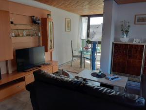 a living room with a couch and a tv and a table at Ferienwohnung JuLe in Winterberg