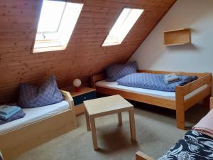 a attic room with two beds and skylights at Ferienwohnung JuLe in Winterberg