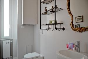 bagno con lavandino, servizi igienici e specchio di Charming Flat Milazzo 32 a Bologna