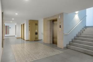 a hallway of a building with stairs and a rug at Carani Hotel Yogyakarta in Yogyakarta