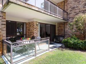 a patio with a table and chairs on a balcony at Bay Parklands 57 ground floor unit with pool tennis court and aircon in Nelson Bay