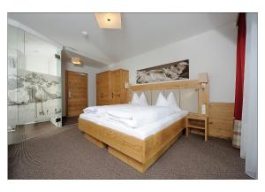 sypialnia z dużym łóżkiem z białą pościelą w obiekcie Apart Garni Schadhof w mieście Ischgl