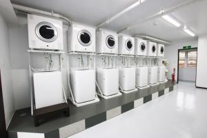 a row of washers and dryers in a laundry room at AMAWARI HOTEL -SEVEN Hotels and Resorts- in Uruma