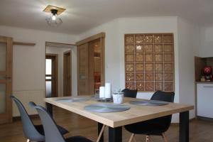 a dining room with a wooden table and chairs at Apartmán Domčeková in Košice +12 photos
