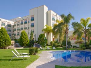 a resort with a swimming pool and palm trees at Fiesta Americana Aguascalientes in Aguascalientes