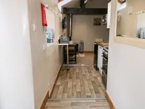 a hallway leading into a kitchen with wood floors at Wren in Scarborough