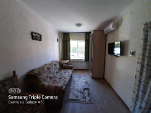 uma sala de estar com um sofá e uma televisão em Rand em Fontanka