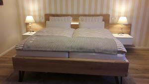 ein großes Bett mit zwei Leuchten auf beiden Seiten in der Unterkunft Ferienwohnung Taubenschlag mit Sauna in Kirchlinteln