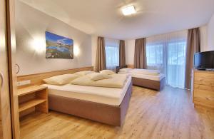 a hotel room with two beds and a television at Hotel Garni Fiegl Apart in Sölden