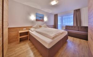 Habitación de hotel con cama grande y sofá en Hotel Garni Fiegl Apart, en Sölden