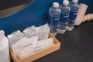 チェンマイにあるBEDGASM Hotel x Cafe Nimmanのテーブルの上に水のボトル入り箱