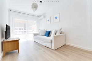 - un salon avec un canapé blanc et une télévision dans l'établissement Marina Alicante Apartment - City Center, à Alicante