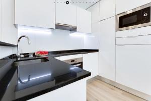 cocina blanca con fregadero y microondas en Marina Alicante Apartment - City Center, en Alicante