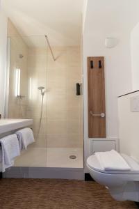 een badkamer met een douche, een toilet en een wastafel bij B&B HOTEL Poitiers Aéroport in Poitiers