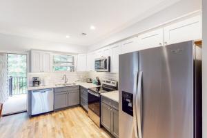 a kitchen with a stainless steel refrigerator and white cabinets at Townsend Timbers in Townsend
