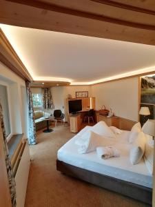 a bedroom with a large white bed in a room at Hotel Sägerhof in Tannheim