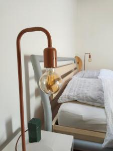eine Lampe auf einem Tisch neben einem Bett in der Unterkunft Alte Hammerschmiede in Sankt Aegidi