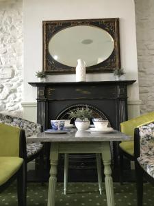 a dining room with a table and a mirror at Falcon Hotel in Carmarthen