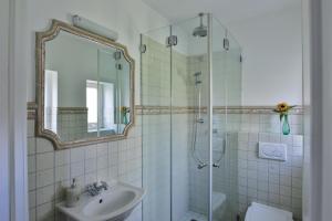 un bagno con lavandino e doccia con specchio di Jan´s Hüs a List Altre 14 foto