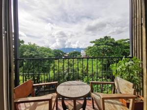 清邁的住宿－L'NER chiang mai，设有一个配有桌椅并享有美景的阳台。