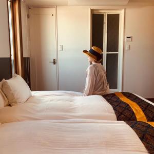 um menino sentado em cima de uma cama em Wright Style em Naoshima