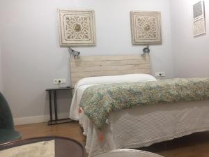 a bedroom with a bed and a chair and a table at Agroturismo Ibarra in Amorebieta-Etxano