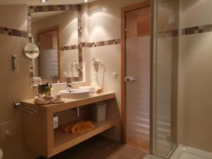 a bathroom with a sink and a shower at Hotel Sägerhof in Tannheim