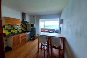 une cuisine avec une table et des chaises dans une pièce dans l'établissement Miramare studio pieds dans l eau vue mer féerique 180 féerique, à Six-Fours-les-Plages
