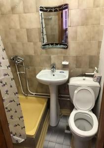 a bathroom with a toilet and a sink and a mirror at Zhemchuzhina Kavkaza Hotel in Zheleznovodsk