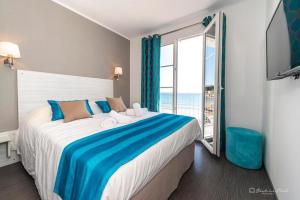 a bedroom with a large bed with a large window at Hôtel George Sand in La Seyne-sur-Mer
