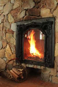 BysławFolwark Minikowo - Agroturystyka w Borach Tucholskich - 5 pokoi z prywatnymi łazienkami的石头壁炉,壁炉内有火