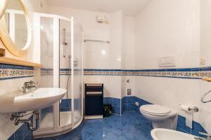 a bathroom with a sink and a shower and a toilet at Hotel Bonapace ***S in Madonna di Campiglio