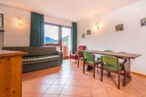 a living room with a couch and a table and chairs at Hotel Bonapace ***S in Madonna di Campiglio