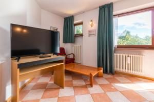 a living room with a large flat screen tv at Hotel Bonapace ***S in Madonna di Campiglio