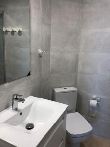 łazienka z umywalką, toaletą i lustrem w obiekcie Torre Levante Plus - Arca Rent w mieście Benidorm +6 zdjęć